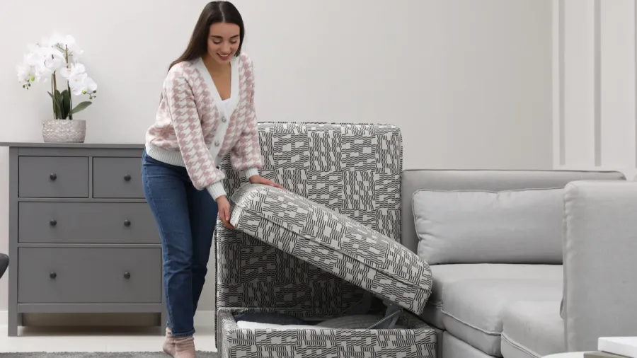 A woman closing modular sofa section with storage in a living room.