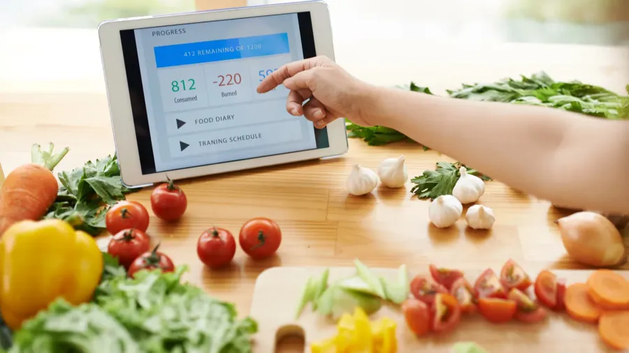 Young adult woman using a diet app on her phone.