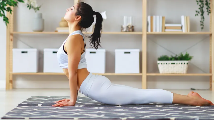 woman doing yoga meditating in lotus position at home