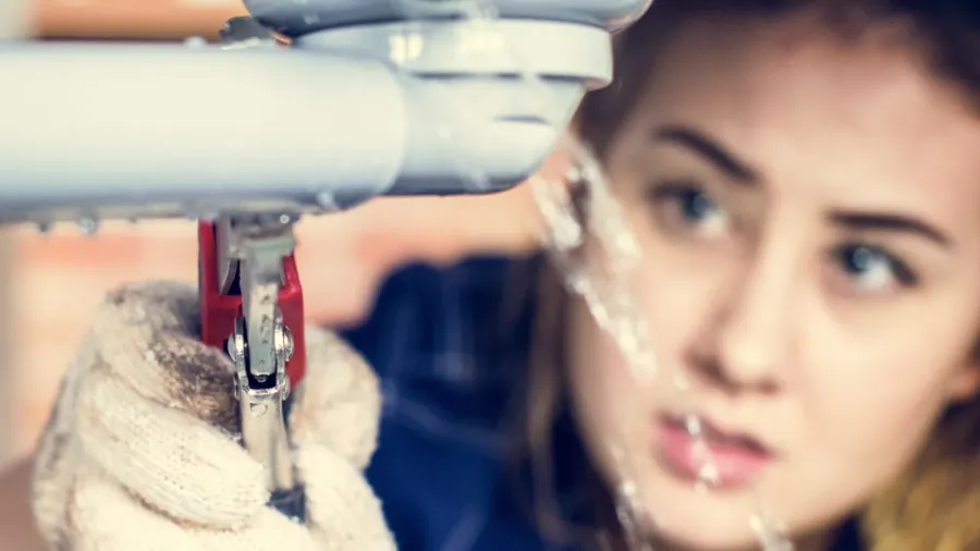 woman fixing kitchen sink