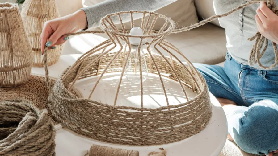 woman makes handmade diy lamp from jute rope at home