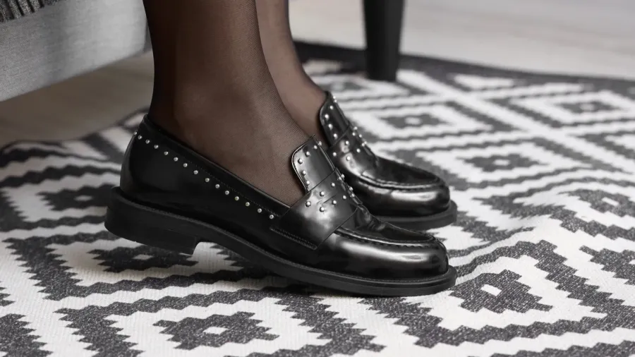 woman wearing stylish black shoes in boutique closeup