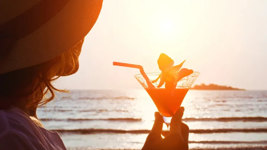 woman with cocktail on the beach