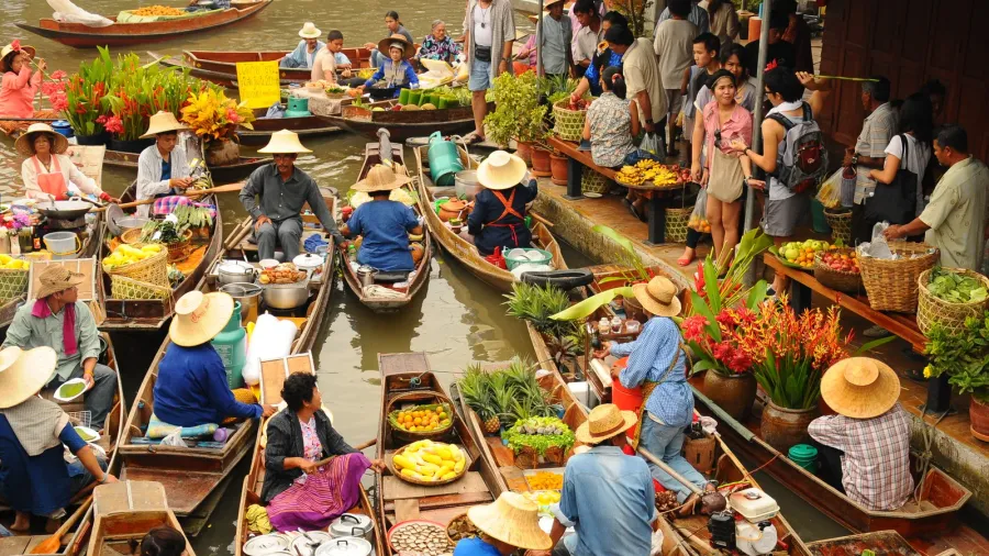 wooden boats busy ferrying people at amphawa floating market on