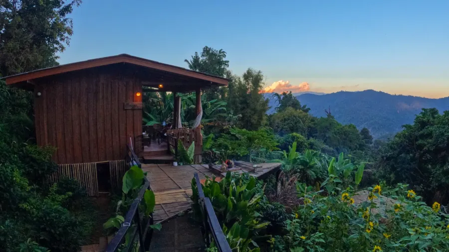 wooden cabin in mountain forest at sunset thailand