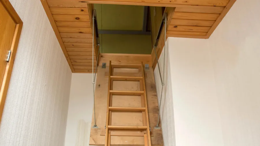 wooden folding ladder to the attic old empty house