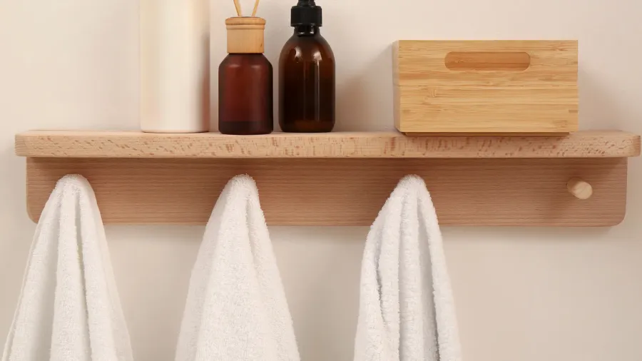 wooden shelf with towels soap dispensers and aromatic reed freshener