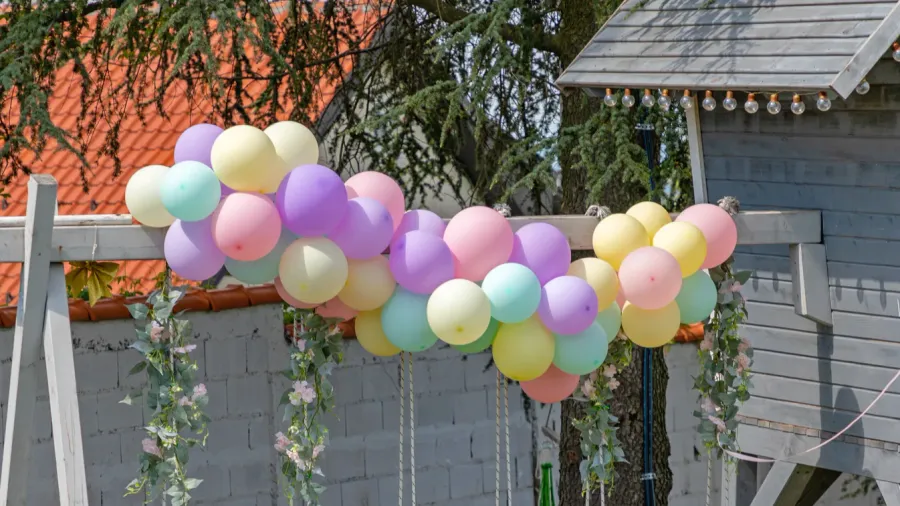 wooden swings and tree house decorated with party balloons