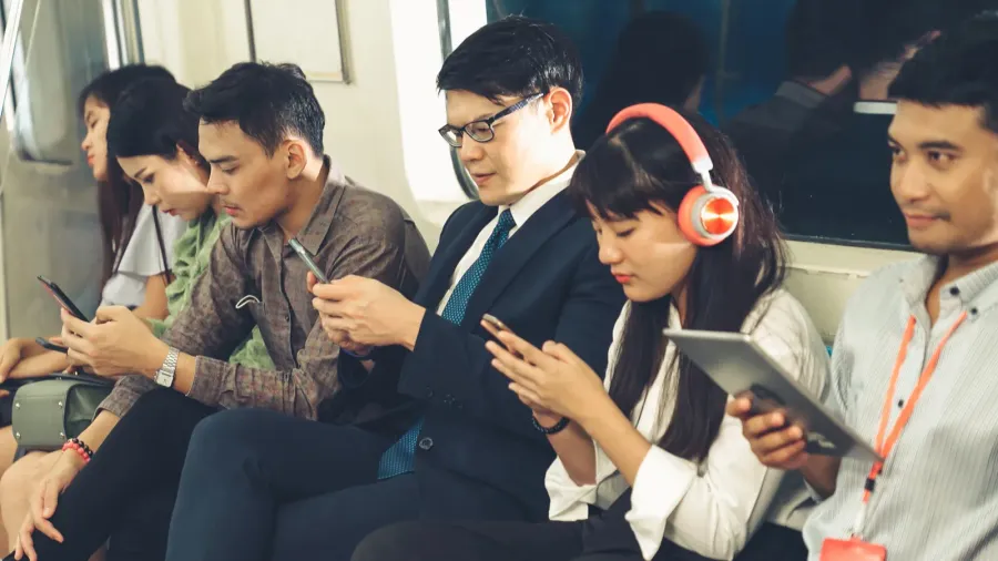 young people using mobile phone in public underground train