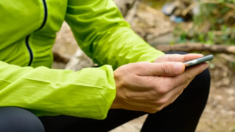 young sportsman outdoors using his smartphone