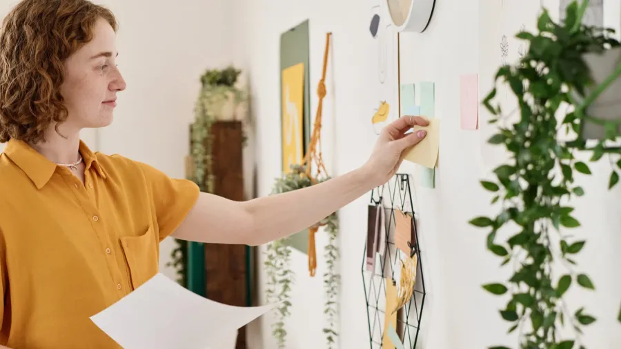 young successful businesswoman with document standing in front of wall