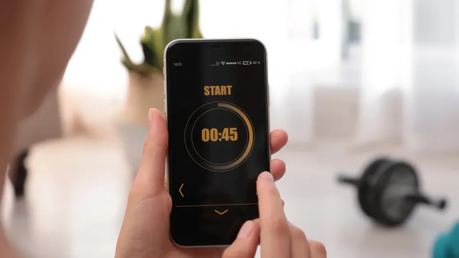 young woman using fitness app on smartphone indoors closeup space