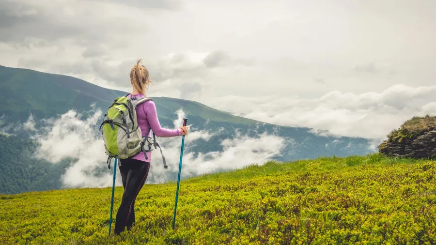 Young woman with backpack hiking in the mountains.