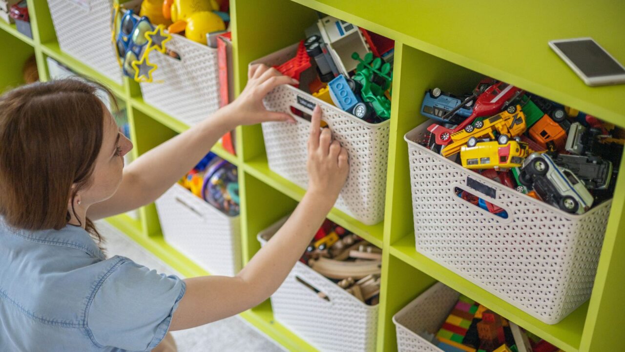 Kid putting toys in storage area