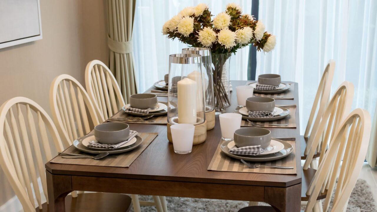 Dining table and comfortable chairs in modern home with elegant table setting