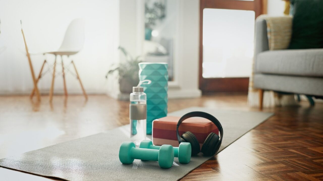 Home gym equipment close up shot, dumbbells, headphone, water bottle and foam roller