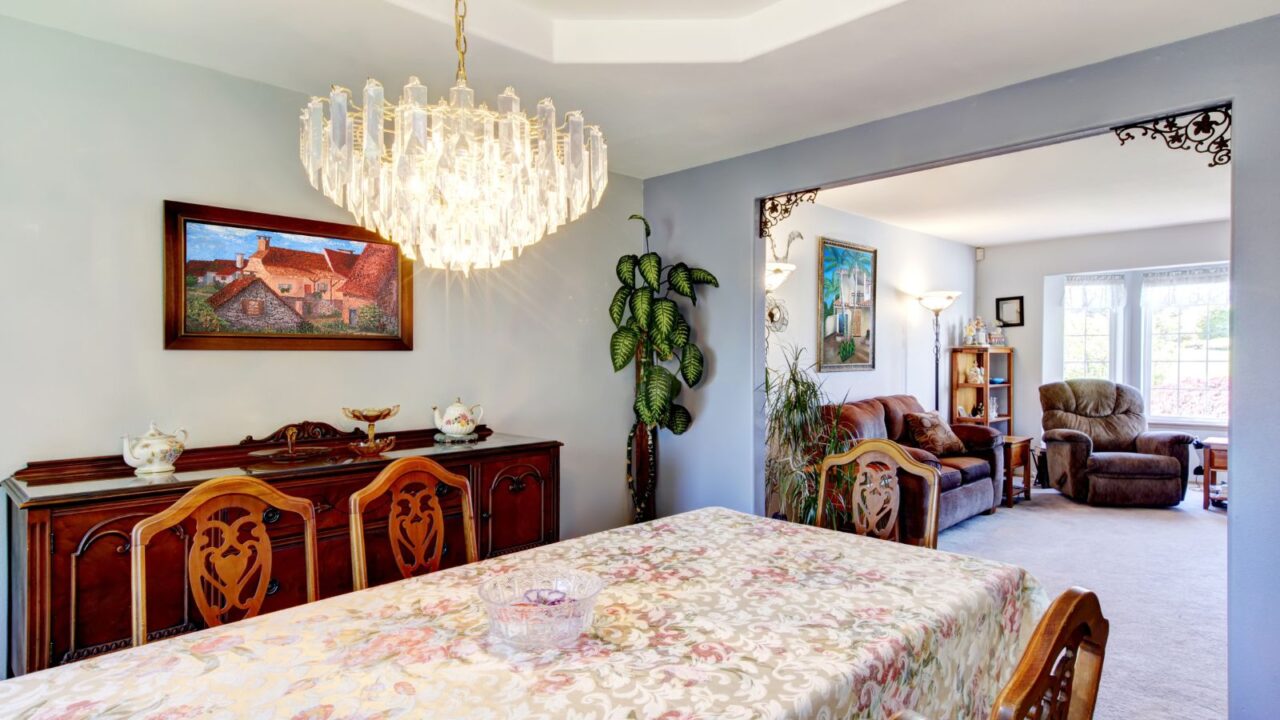 Dining room with a large table and art in an outdated American house.