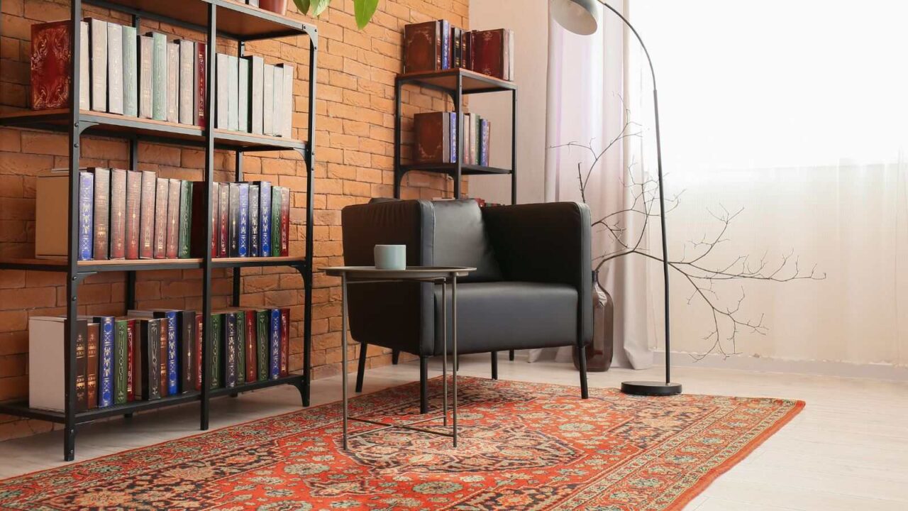 Study room layout with black chair, coffee table, and book case with books