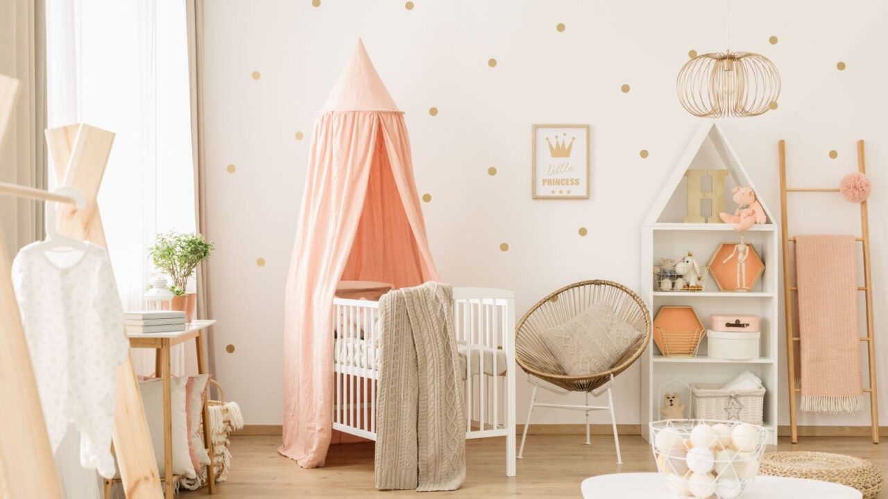 A brightly lit baby nursery setup in pink and beige tones