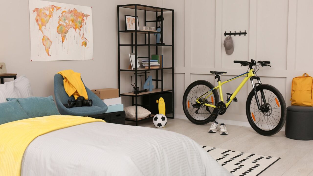 A bedroom decorated with black white and yellow along with some football elements.