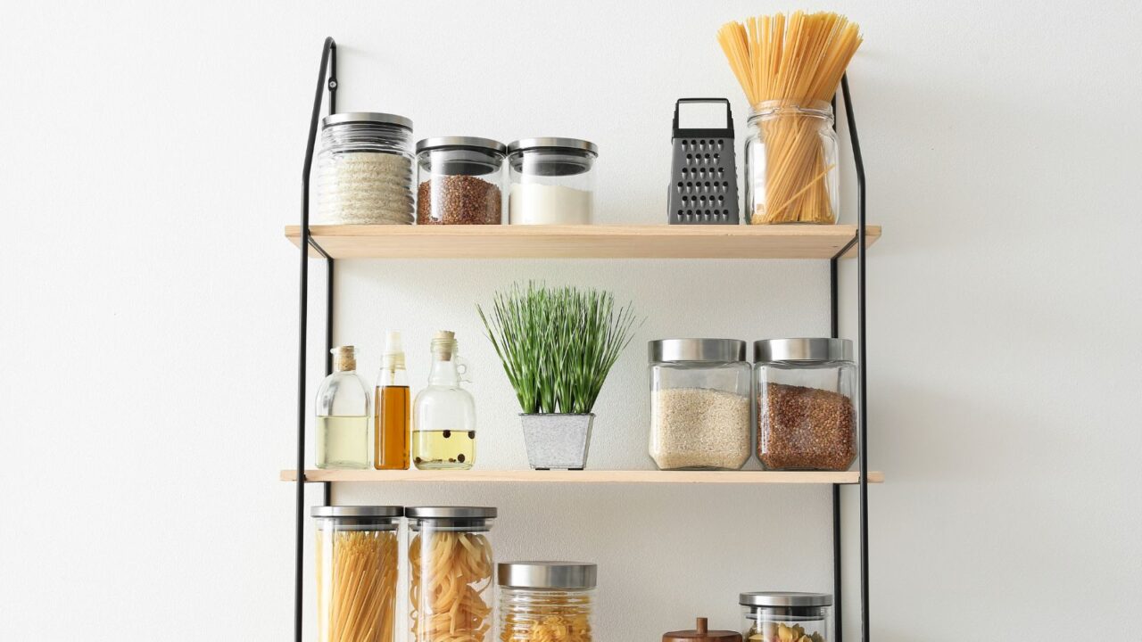 Set of jars with products on kitchen shelves