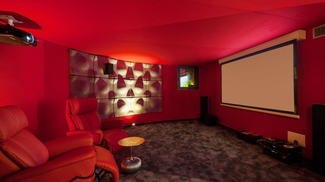 Home theatre in red theme with red recliners, red walls and projector screen