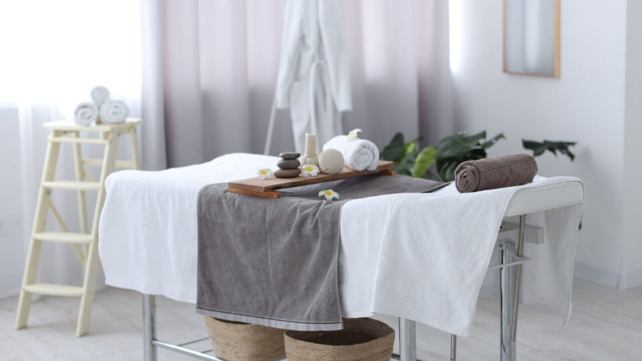 Massage table with all the spa essentials in a bright room