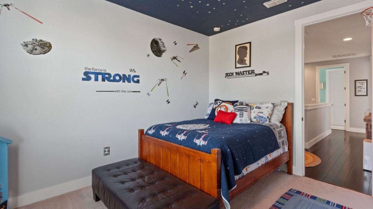 Star Wars themed bedroom with star wars stickers on wall and bedding on bed