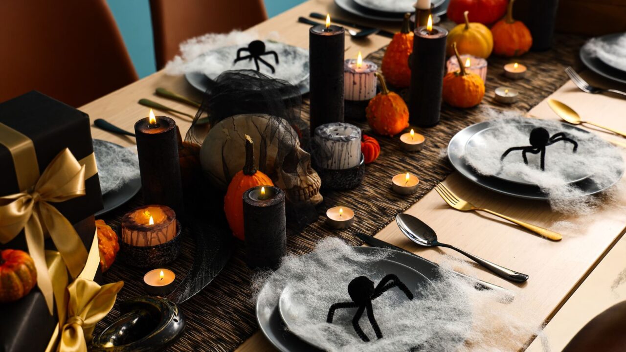 A Halloween-themed dining table setup in black and orange accents