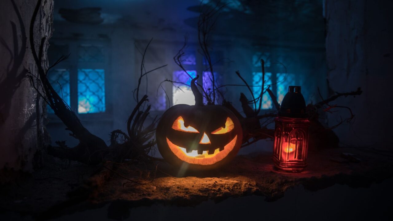 Scary Halloween pumpkin in the mystical house window at night or halloween pumpkin in night on abandoned room with window.