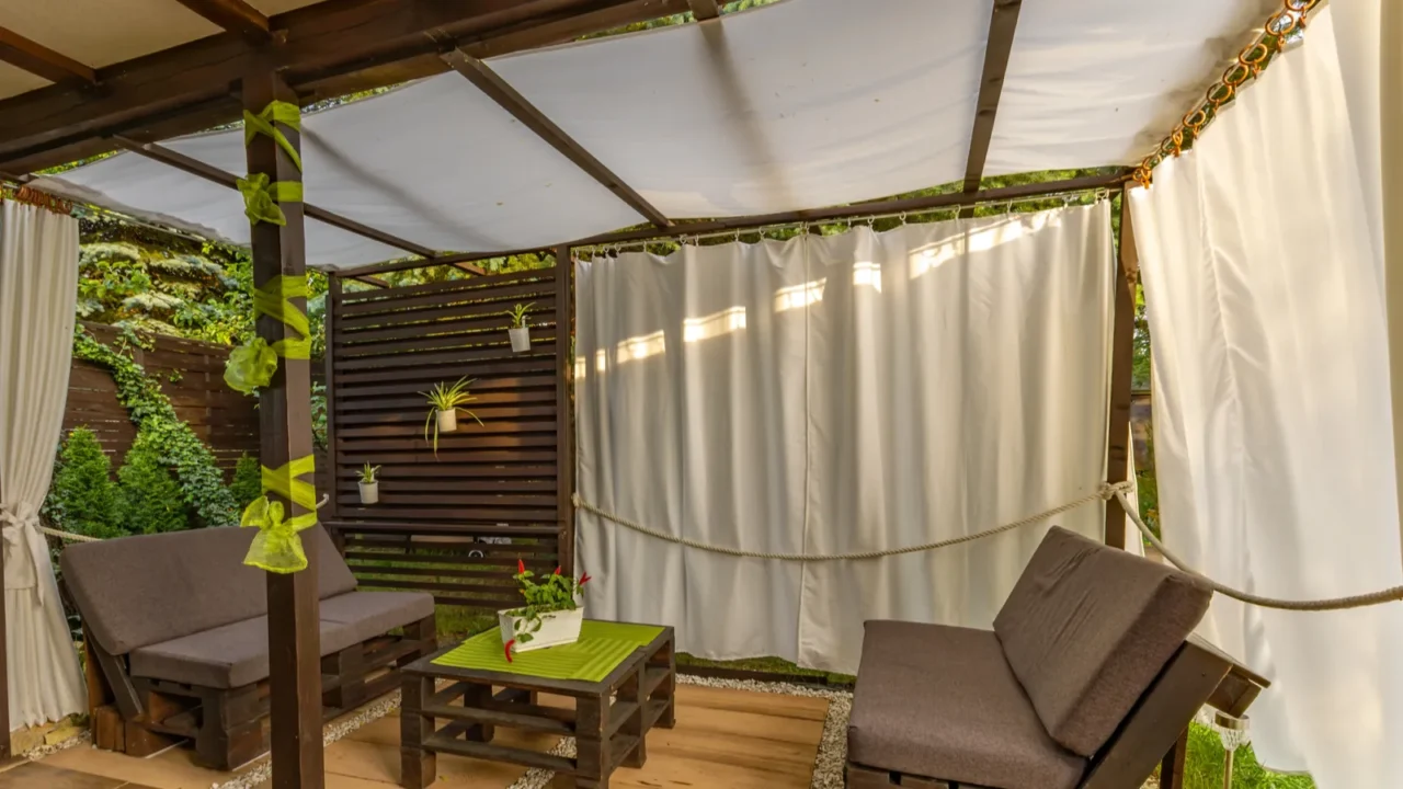 Garden terrace, resting place, garden furniture made of wooden pallets, pergola and flowers