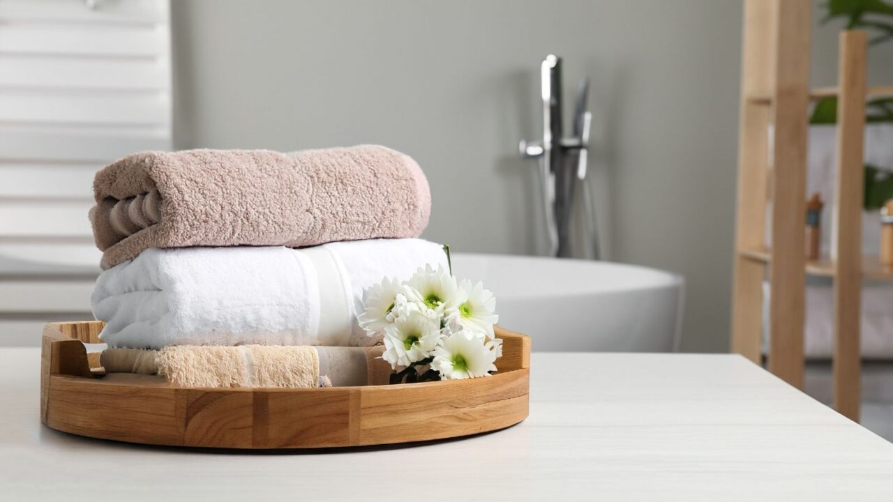 Wooden tray with folded towels.