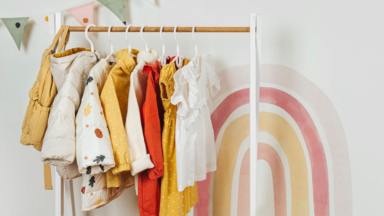 Wooden clothes hanging rack with children's fall outfits