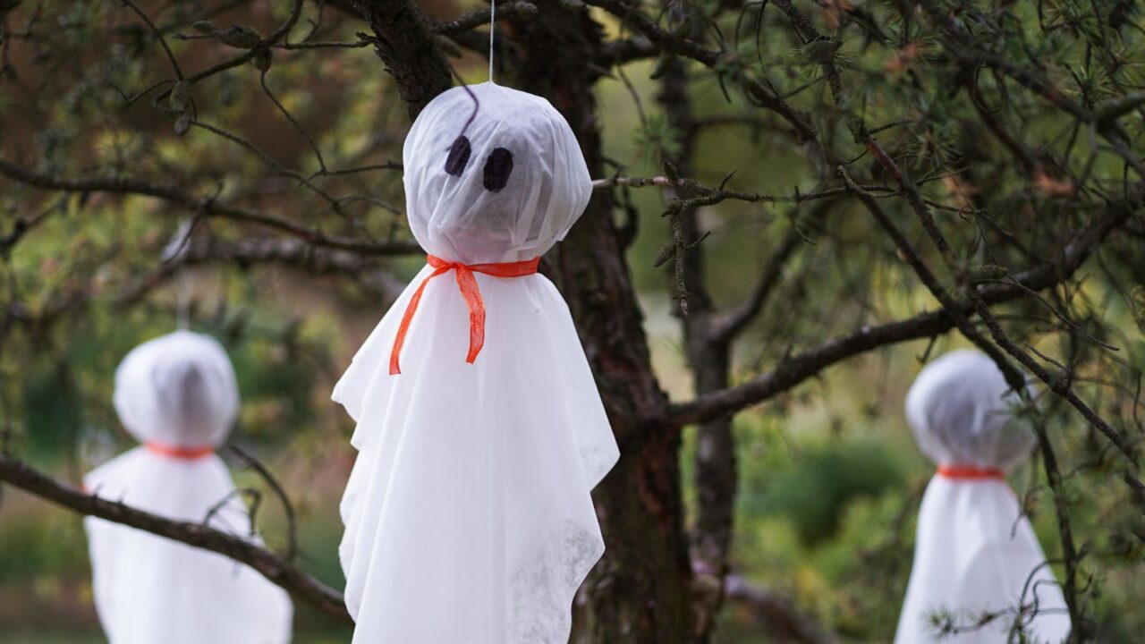 Halloween decoration - white ghosts hanging on tree.