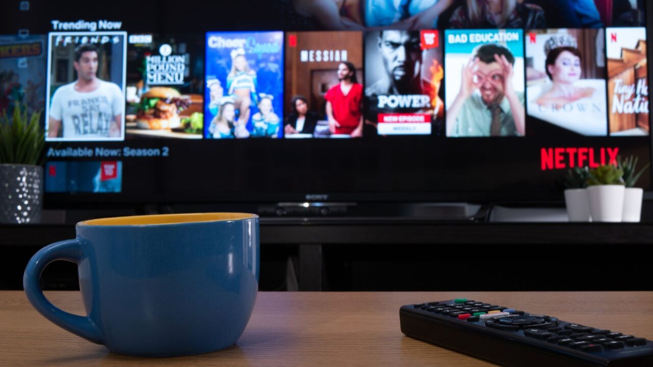 Blue coffee mug and remote with Smart TV in the background