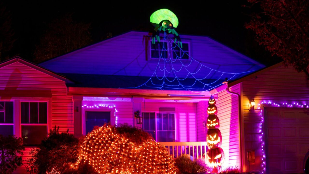 Inflatable giant spider on a roof of a home with decorated porch