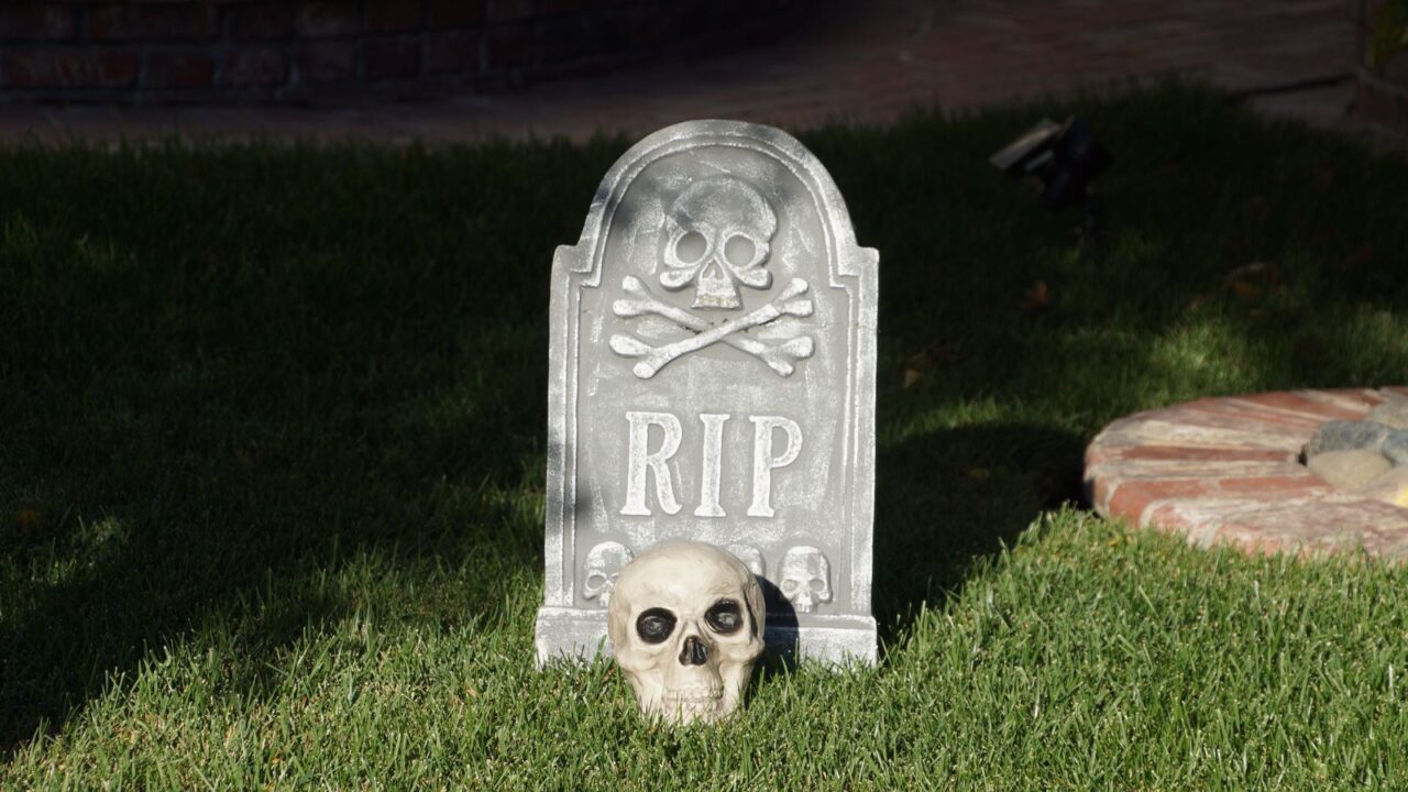 halloween decor of a tombstone with a skull in front of it