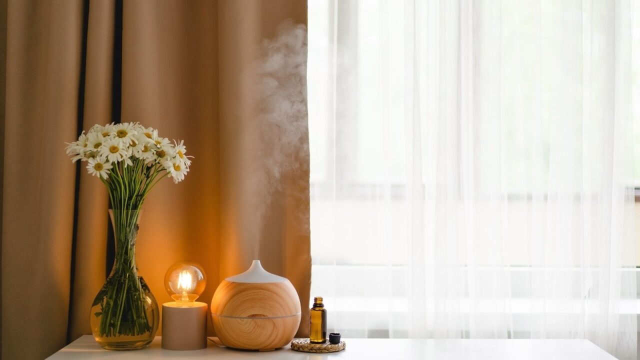 diffuser, vase, small table bulb, and essential oil on a table