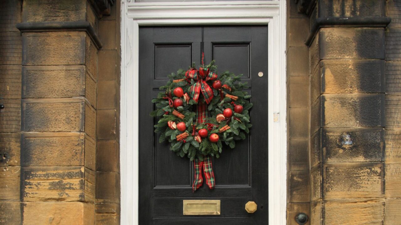 apple and cinnamon stick wreath on a front door