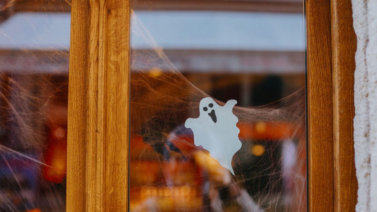 ghost cutout and spider web halloween decor on window