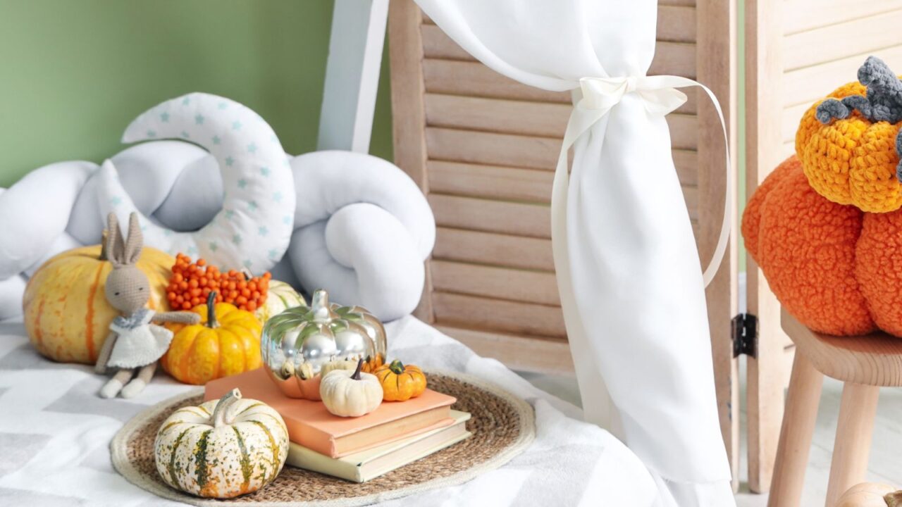 Stool with a toy, pumpkins, and books in children's bedroom. Fall decor.