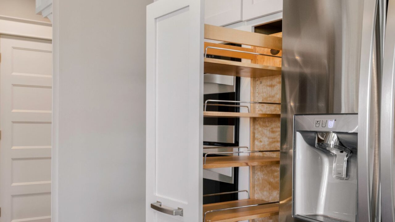 Modern kitchen with pull-out pantry on wheels.