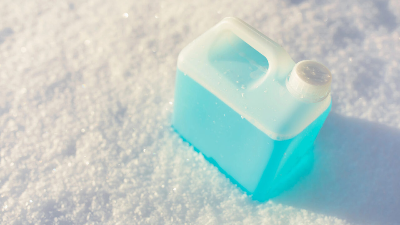 bottle with non-freezing windshield washer fluid, snow background