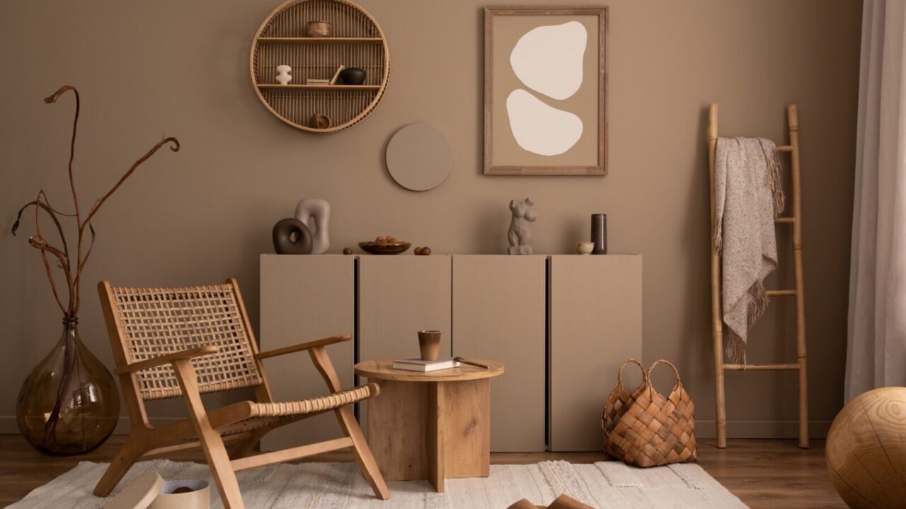 Living room set up in earthy tones with rattan chair, clay walls, and wooden accents