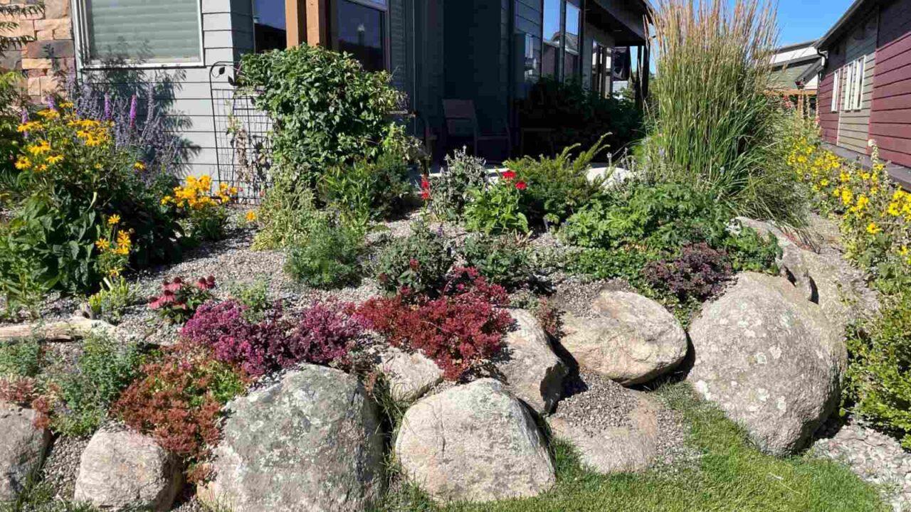 Beautiful landscaping outside a residential home with large rocks and flowers