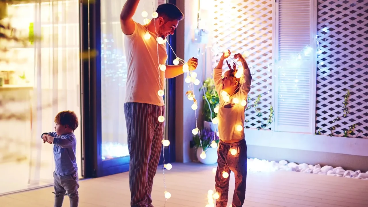 happy family, father with sons decorate open space patio area with christmas garlands