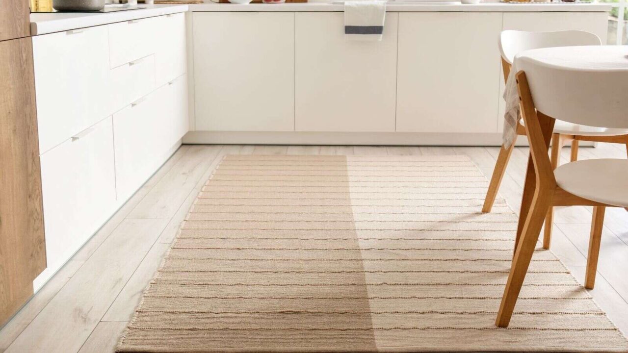 Stylish beige rug in interior of modern kitchen