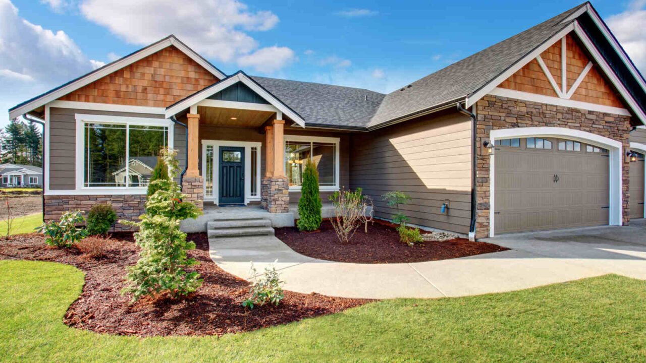 Large modern house exterior with stone walkway and lawn