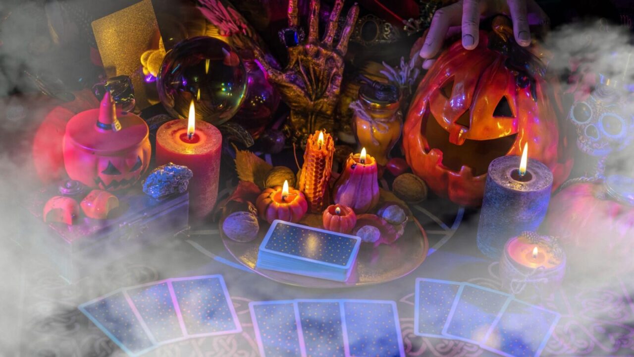 Mystical Halloween decor theme. Tarot cards, candles, skulls, and carved pumpkins used as decor