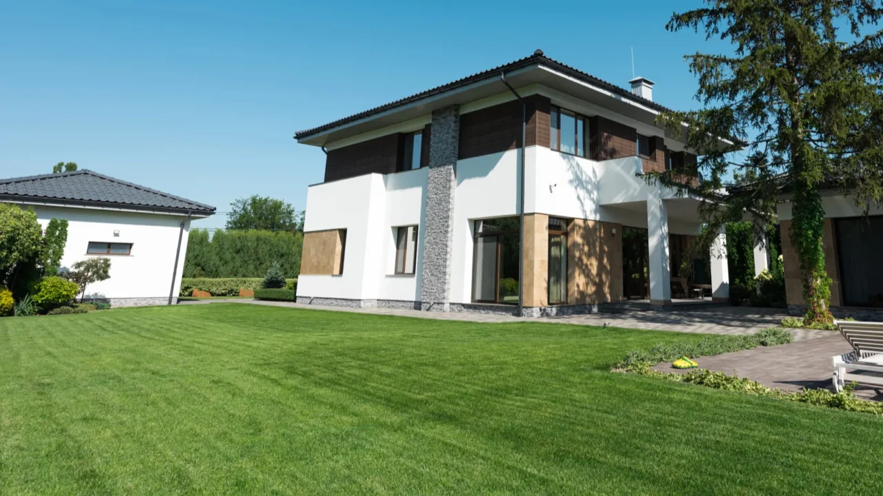 view of new modern house with swimming pool and green lawn